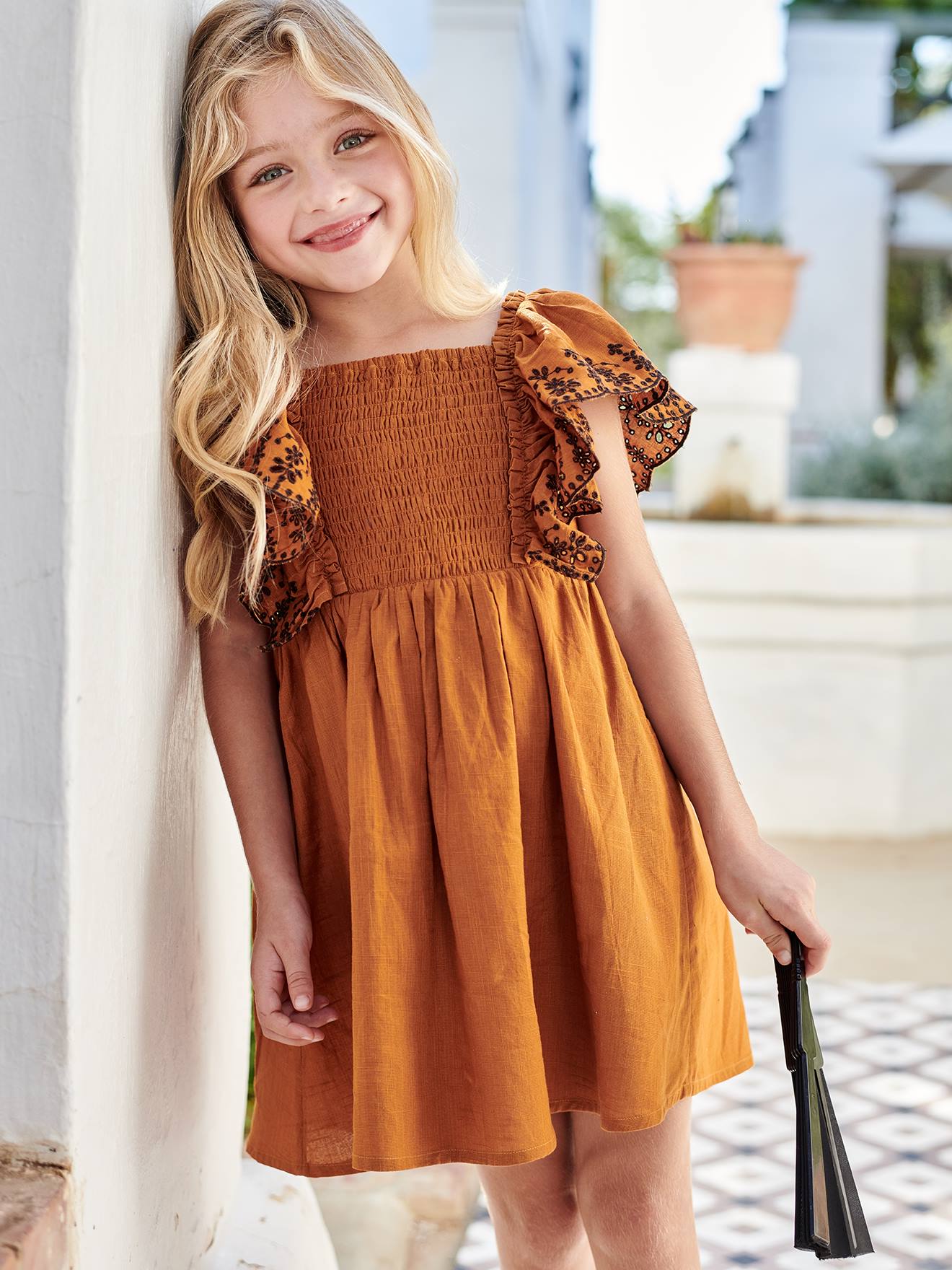 Vestido infantil em tons pastel com babados e mangas bordadas.
