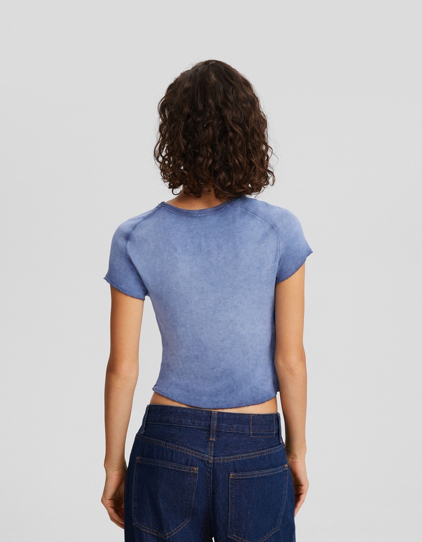 Camiseta de manga curta com efeito desbotado e aplicações de strass.