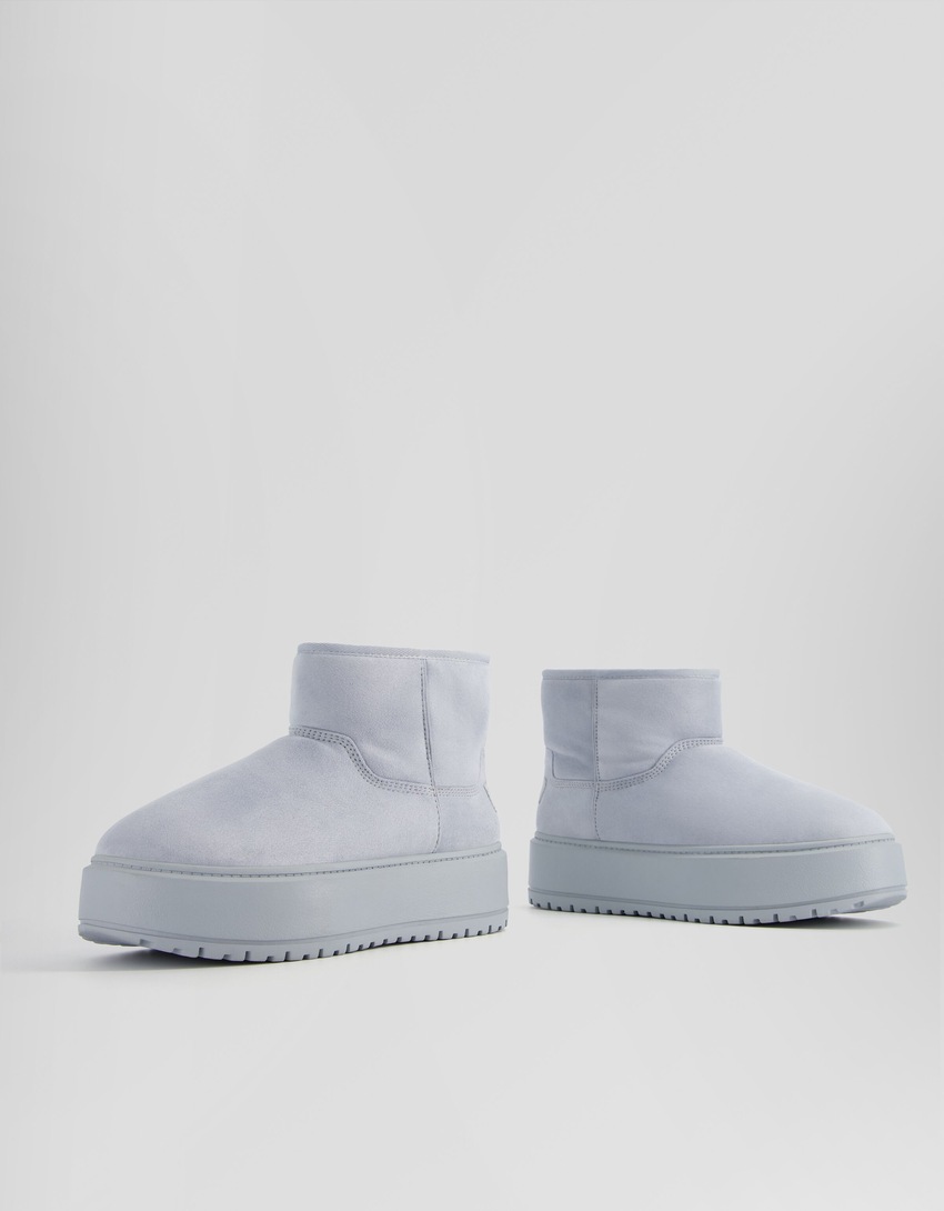Botas de cano curto com plataforma e forro de pele sintética.