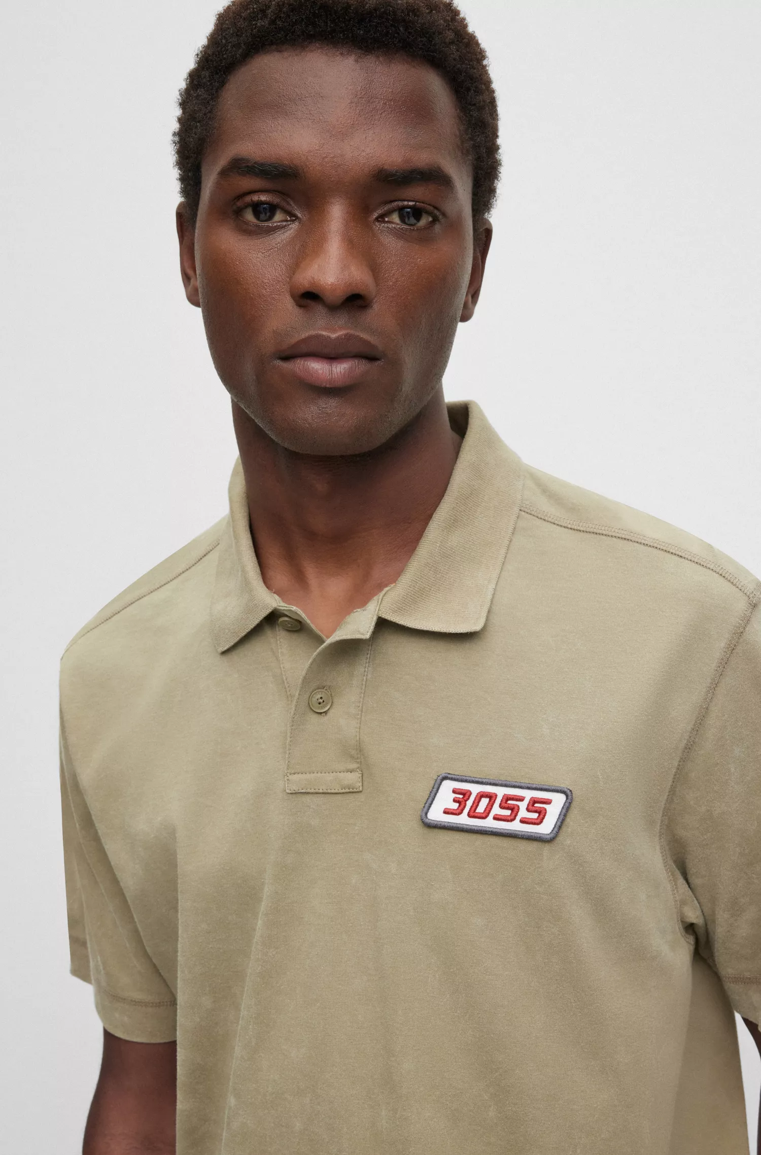 Camisa polo BOSS laranja, modelagem relaxada, em algodão com toque de pêssego e etiqueta com o logotipo.