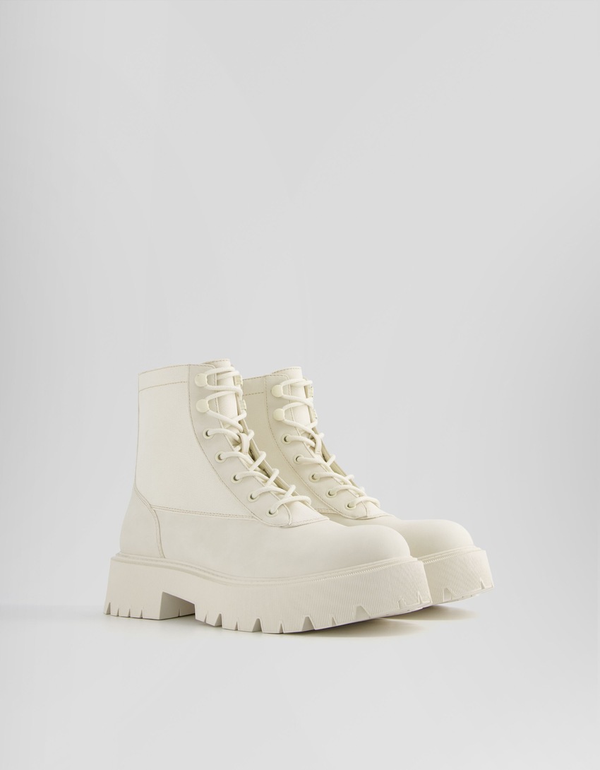 Botas de cano curto com cadarço e modelagem rasteira contrastante