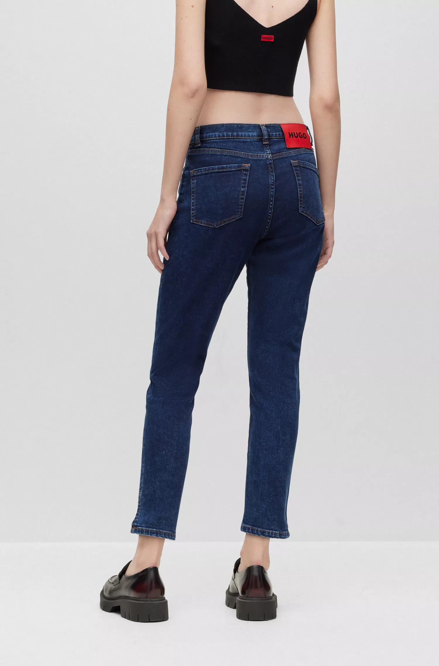 Calça jeans HUGO vermelha, corte slim, em denim elástico com fendas na barra.