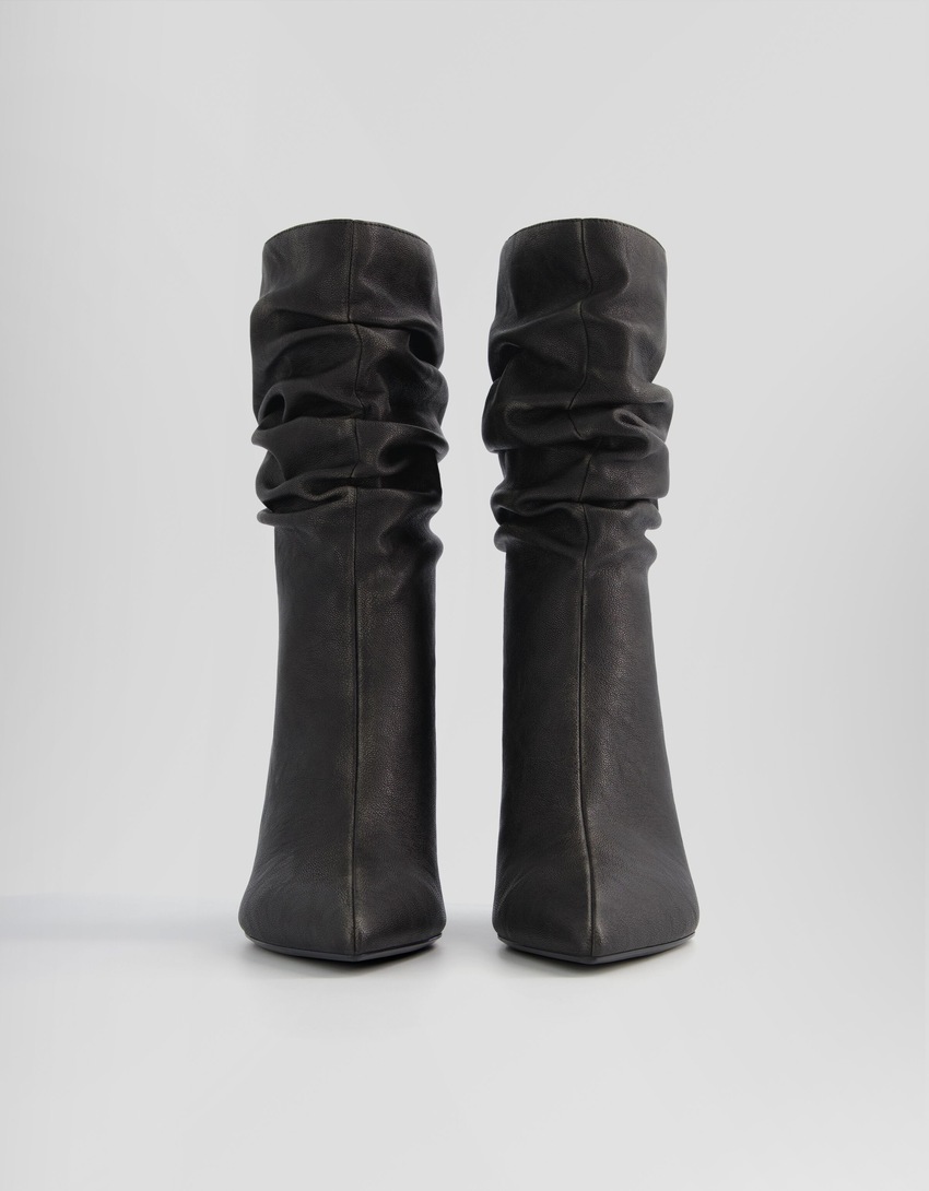 Botas de cano curto com salto agulha e modelagem folgada