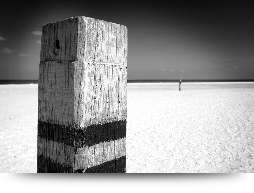 Strandpaal in zwart-wit - Acrylglas schilderij 90 x 60 cm