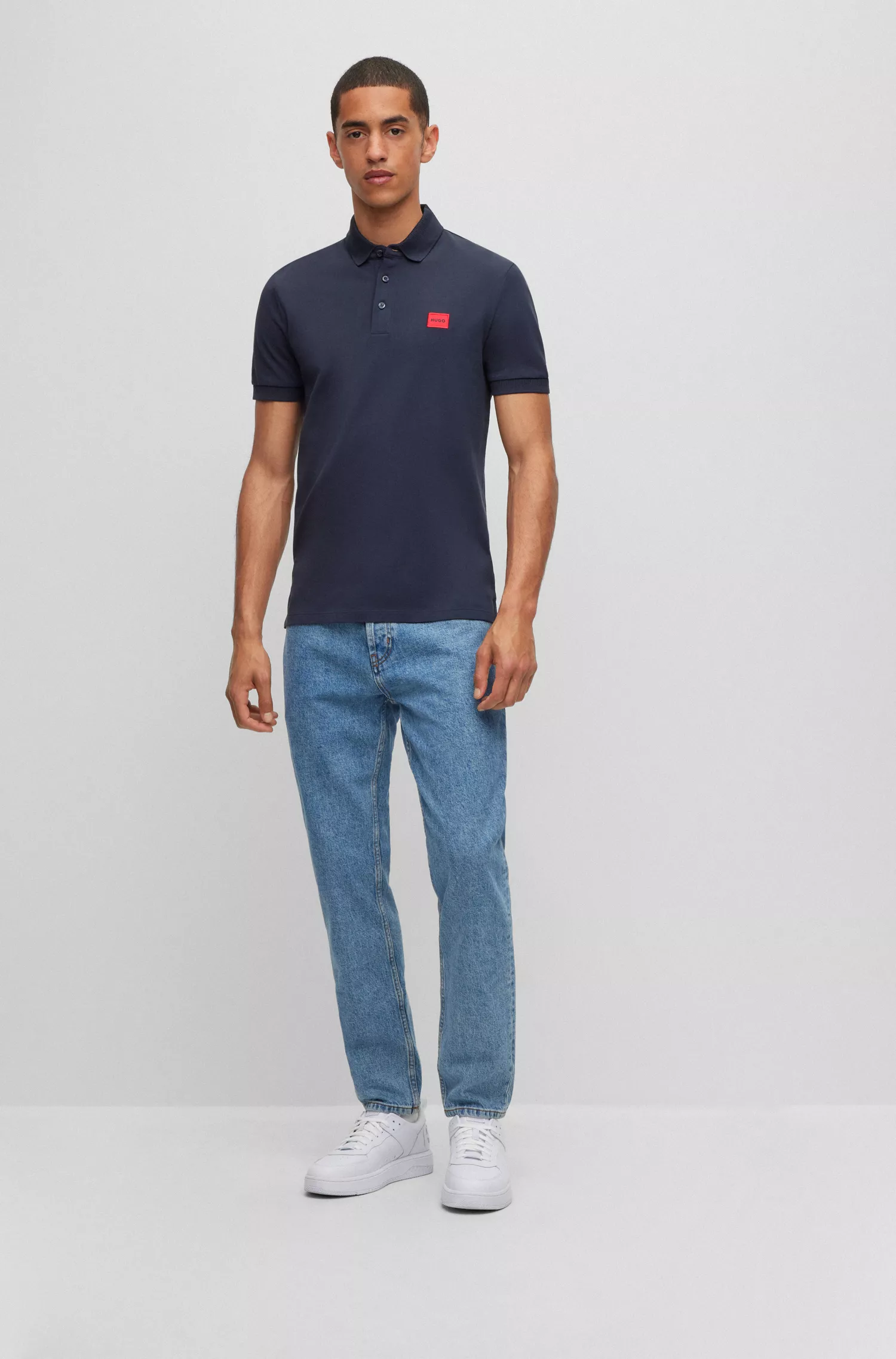 Calça jeans HUGO vermelha, corte afunilado, em denim azul com elasticidade confortável.
