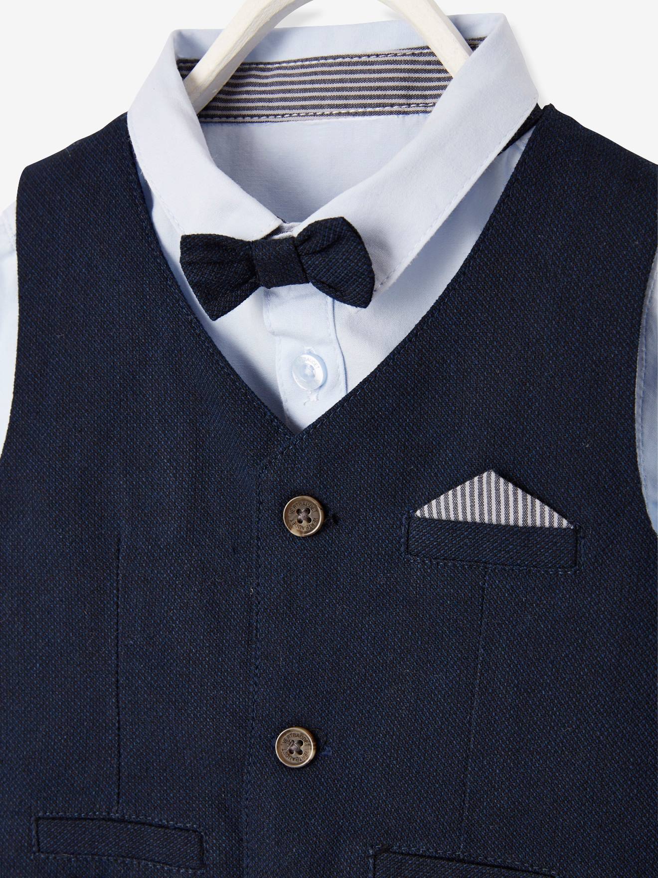 Conjunto formal para bebê menino com colete de tricô, camisa, gravata borboleta e calça azul-escura lisa.