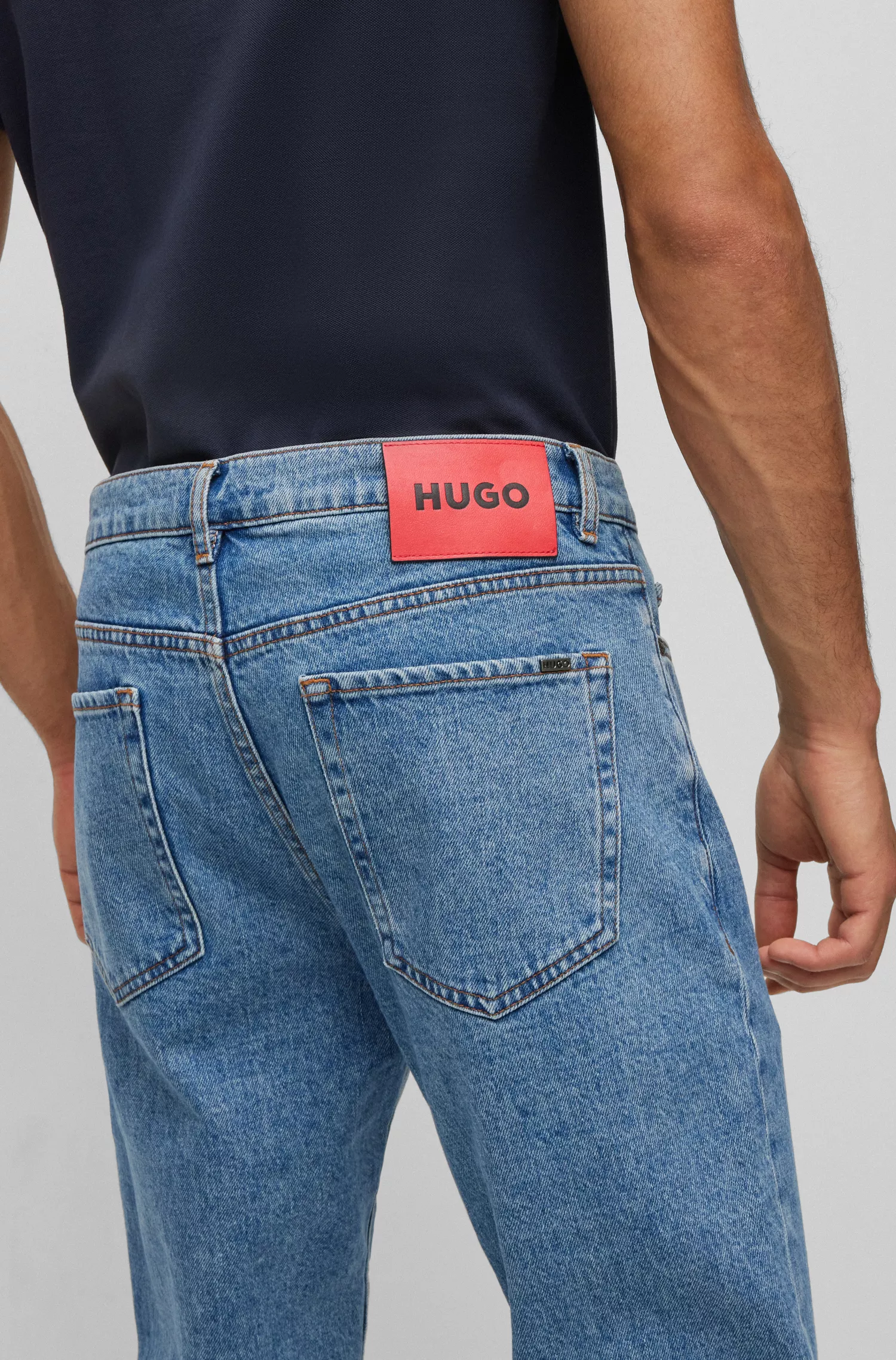 Calça jeans HUGO vermelha, corte afunilado, em denim azul com elasticidade confortável.