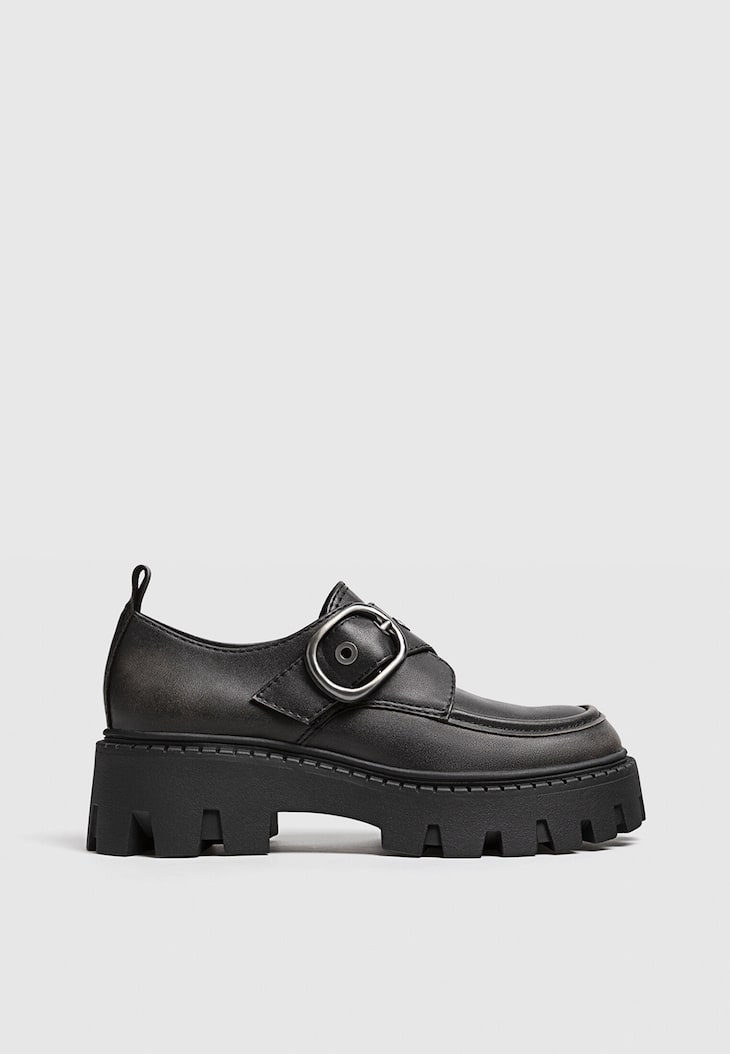 Sapatos baixos com fivela e solado tratorado.
