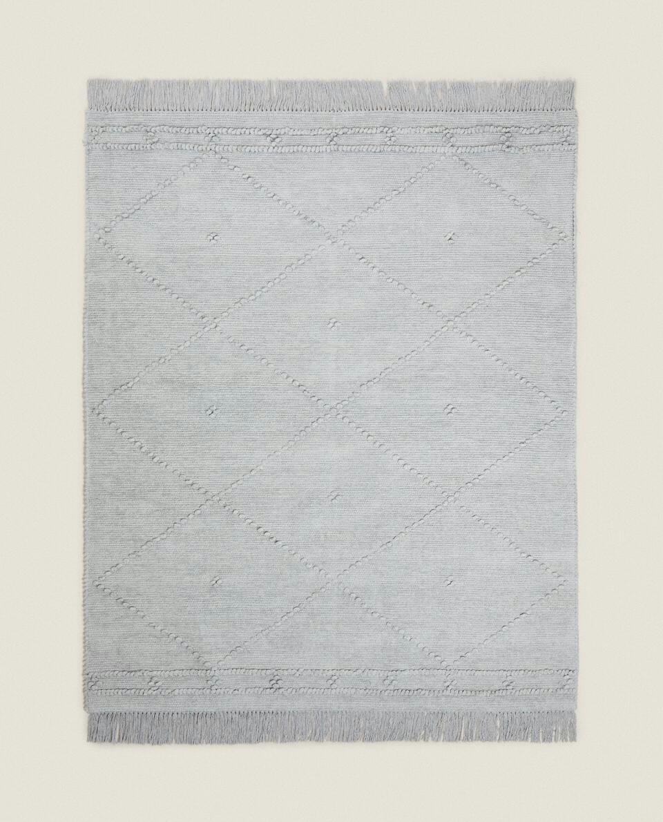 Tapete infantil de chenille com estampa de diamante e franjas.