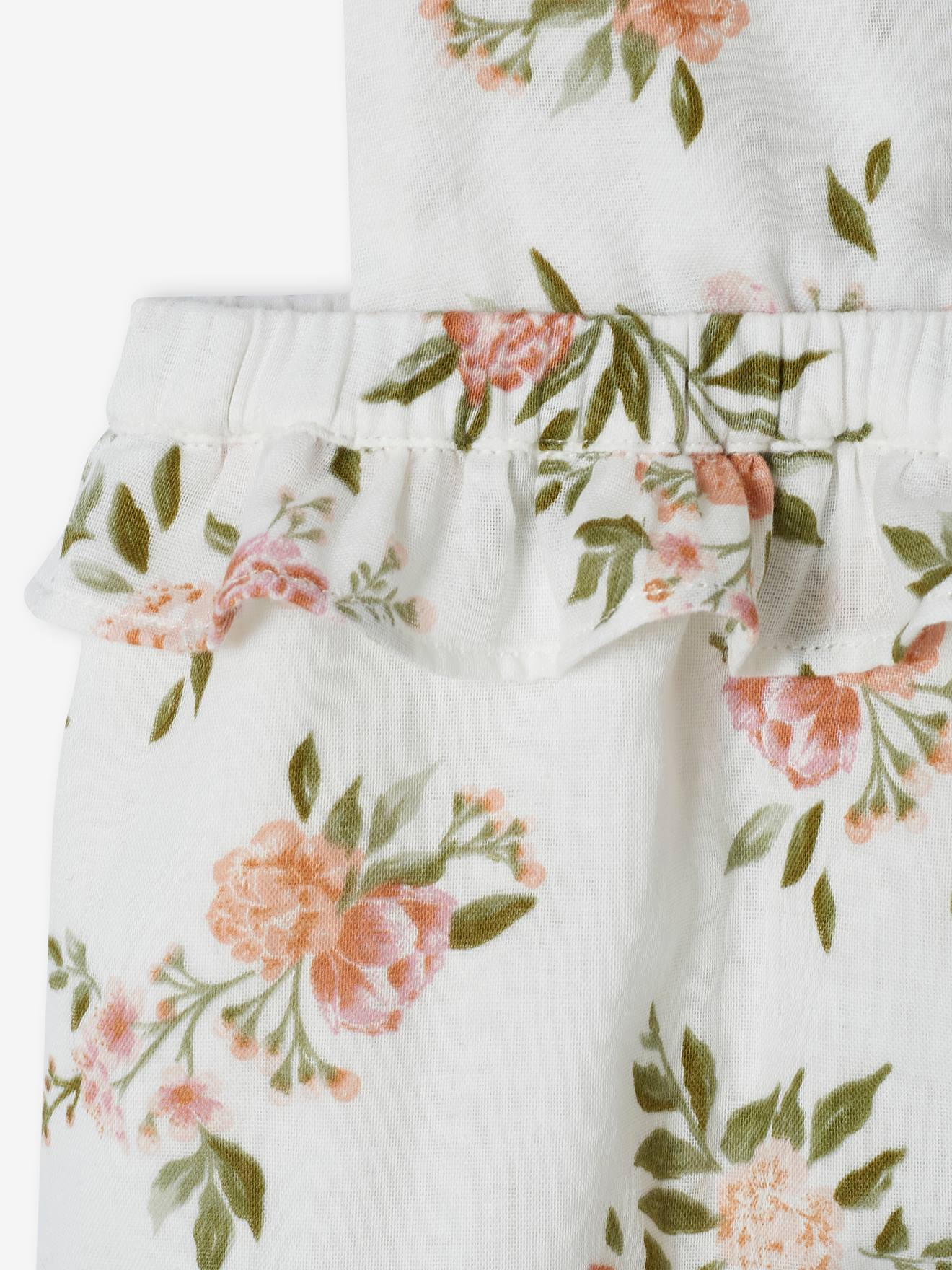 Macacão branco para bebê com estampa floral e suspensórios.