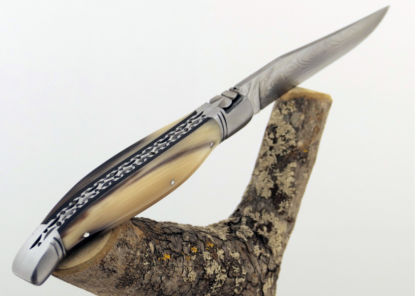 Couteau Laguiole prestige avec un manche en pointe de corne blonde et mitres en acier inoxydable et lame Damas
