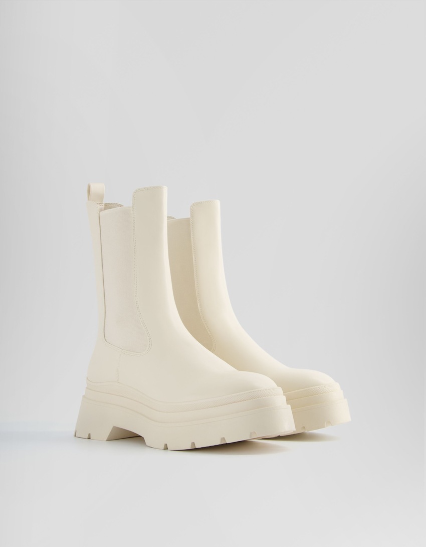 Botas de cano curto com elástico e sola tratorada.