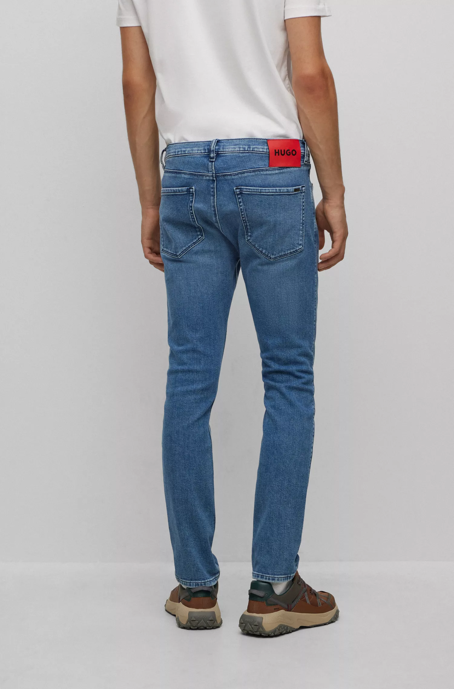Calça jeans HUGO vermelha, extra slim fit, em denim azul supermacio.