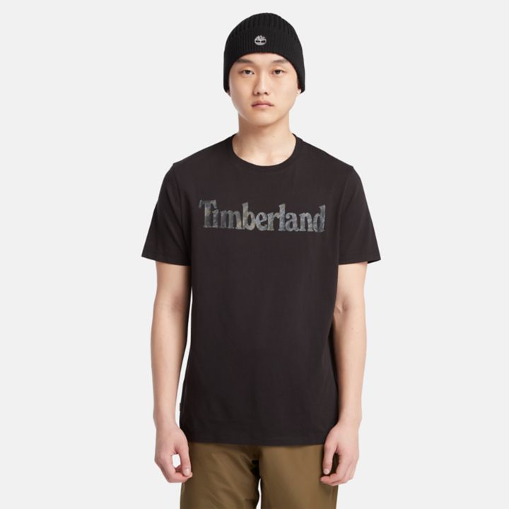 Camiseta masculina preta com estampa camuflada e logo.