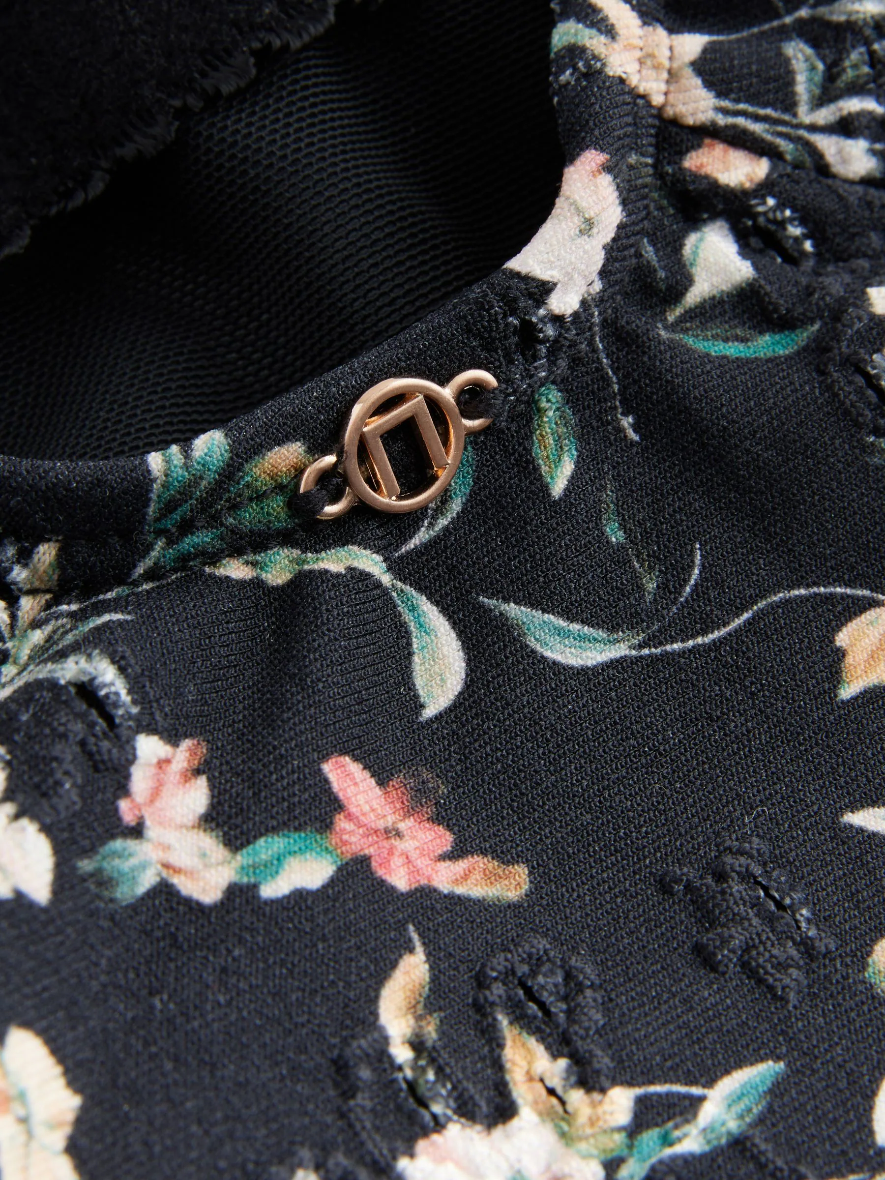Zwart met broderie en fijne print - Badpak met vormgevende zijrimpeling en buikcorrectie