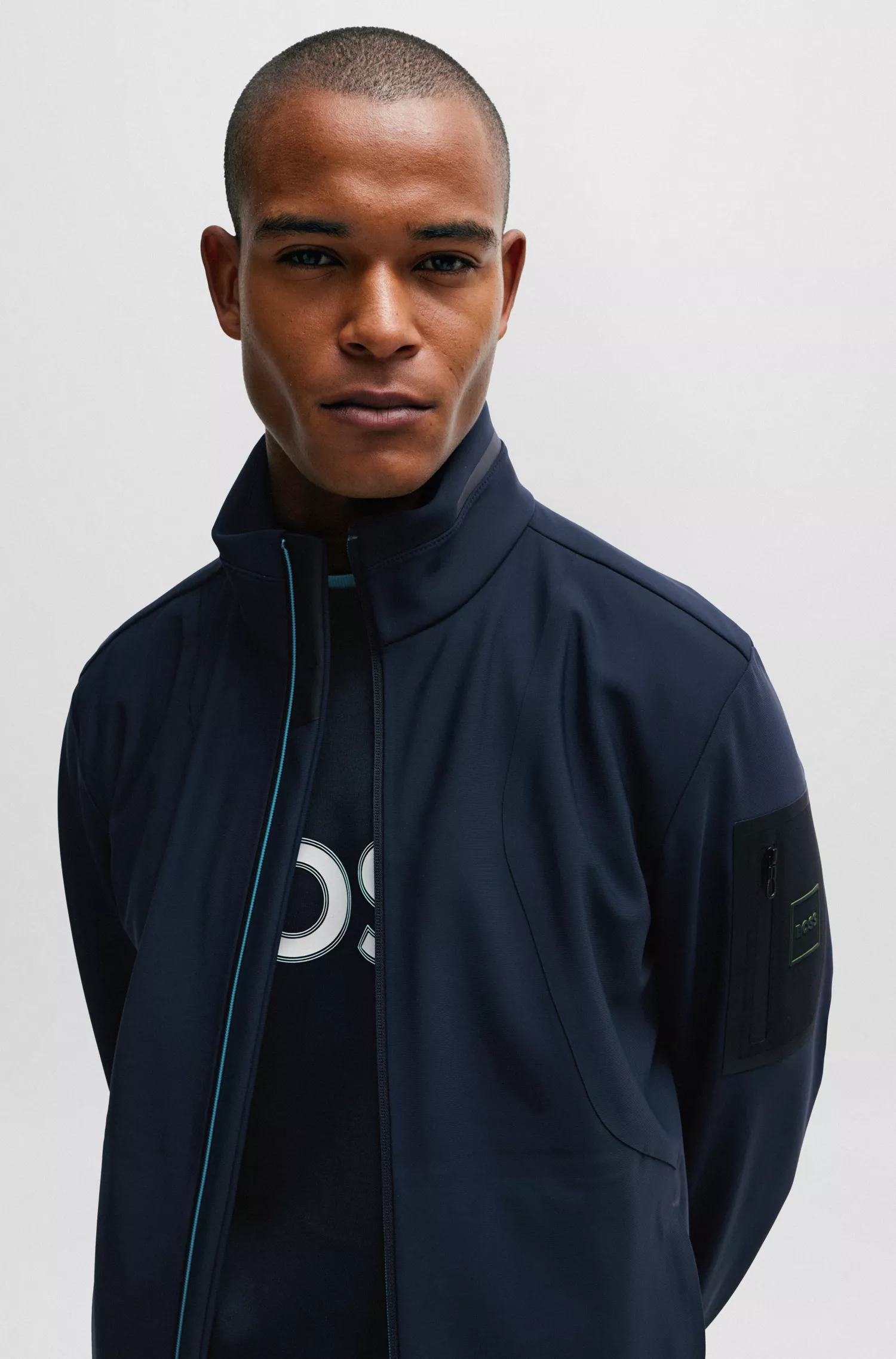 Jaqueta softshell verde-repelente à água da BOSS com bolso na manga com a marca.