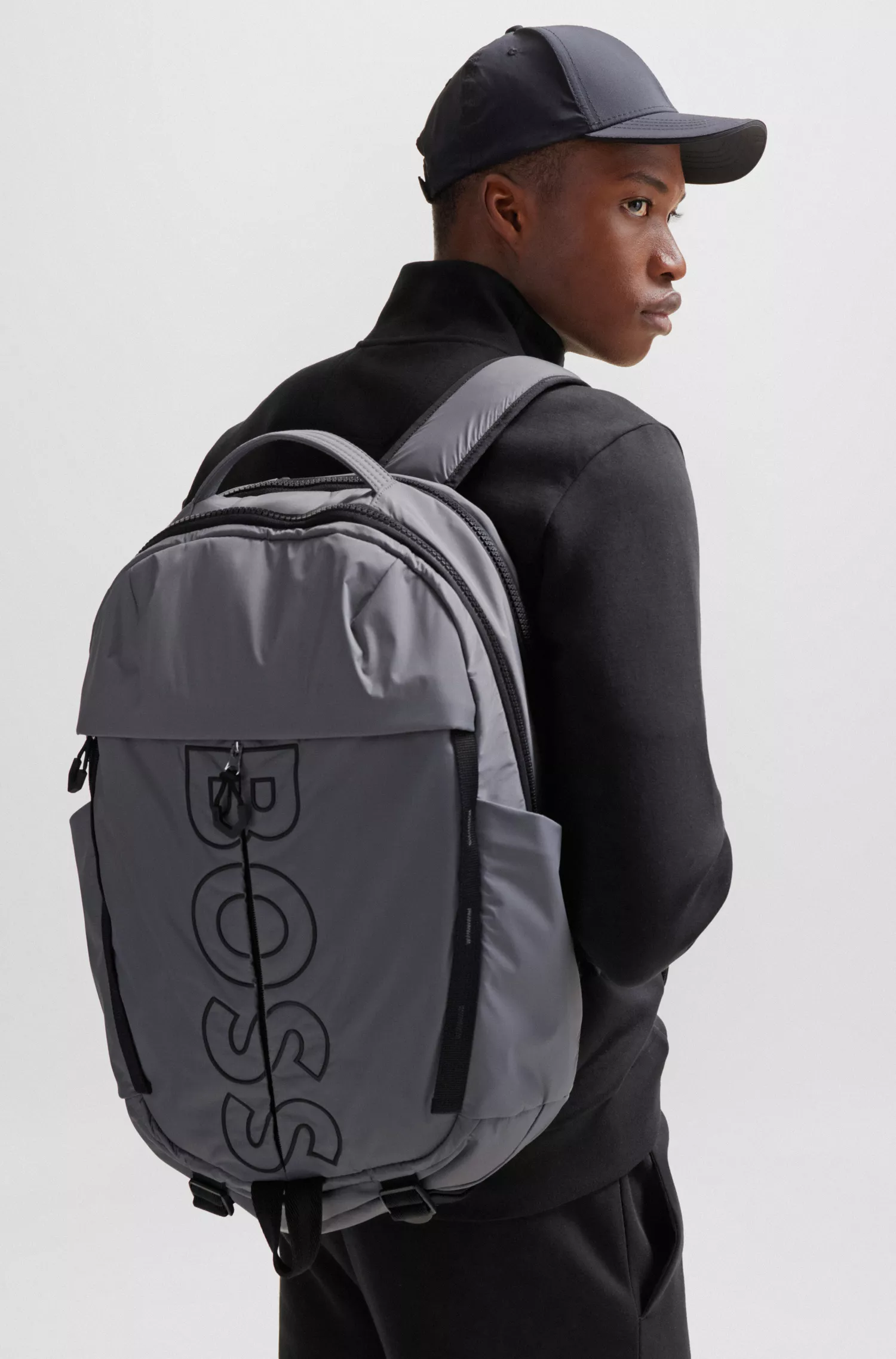 Mochila BOSS preta revestida em veludo com vários bolsos e logotipo em contorno.