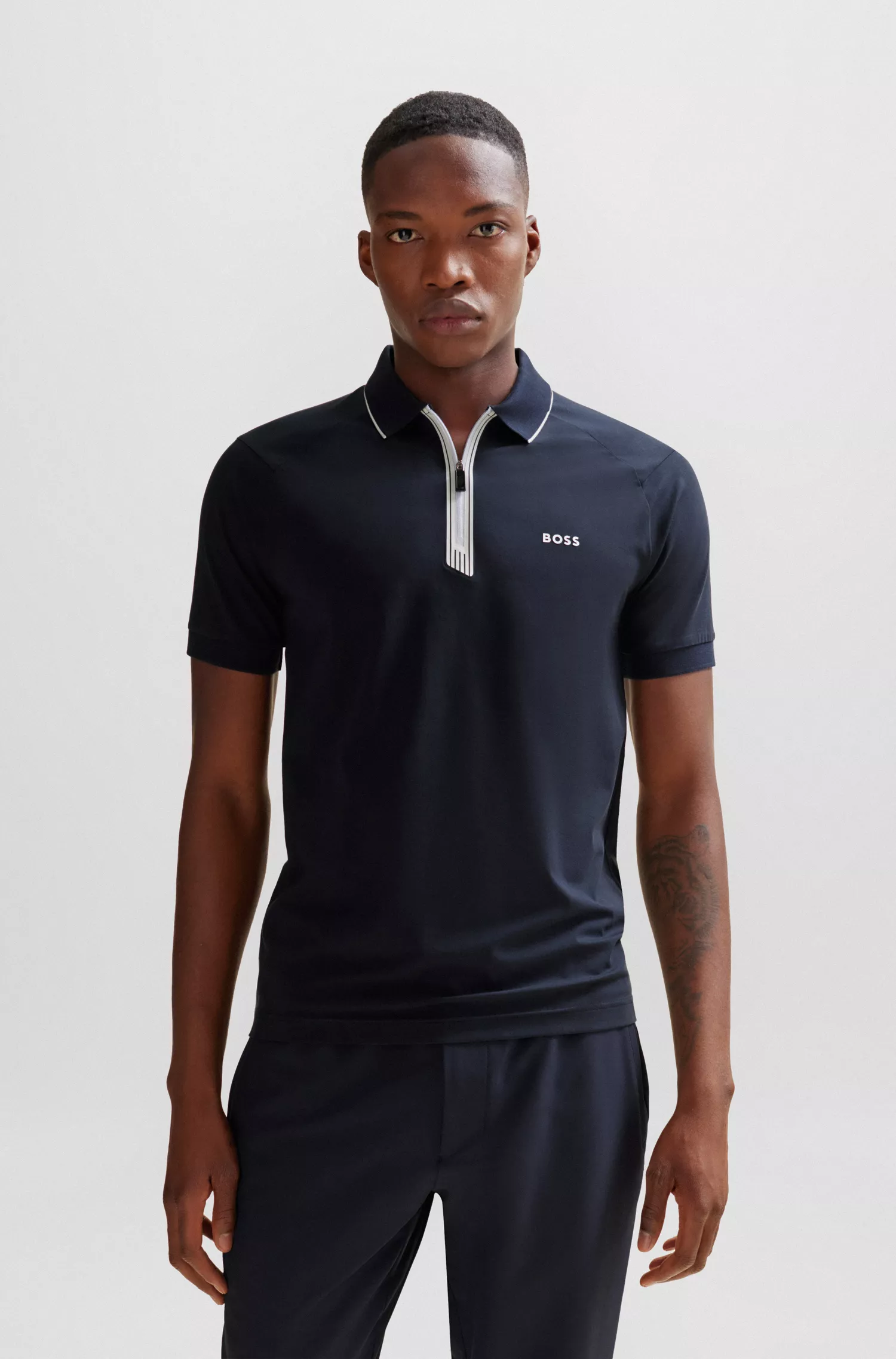 Camisa polo BOSS verde, de algodão stretch, corte slim, com fecho de zíper.