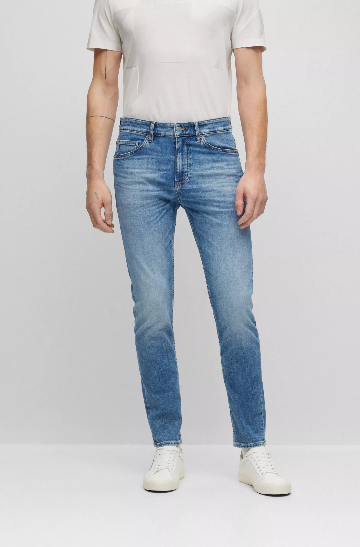 Calça jeans BOSS preta, corte afunilado, em denim italiano stretch azul médio.