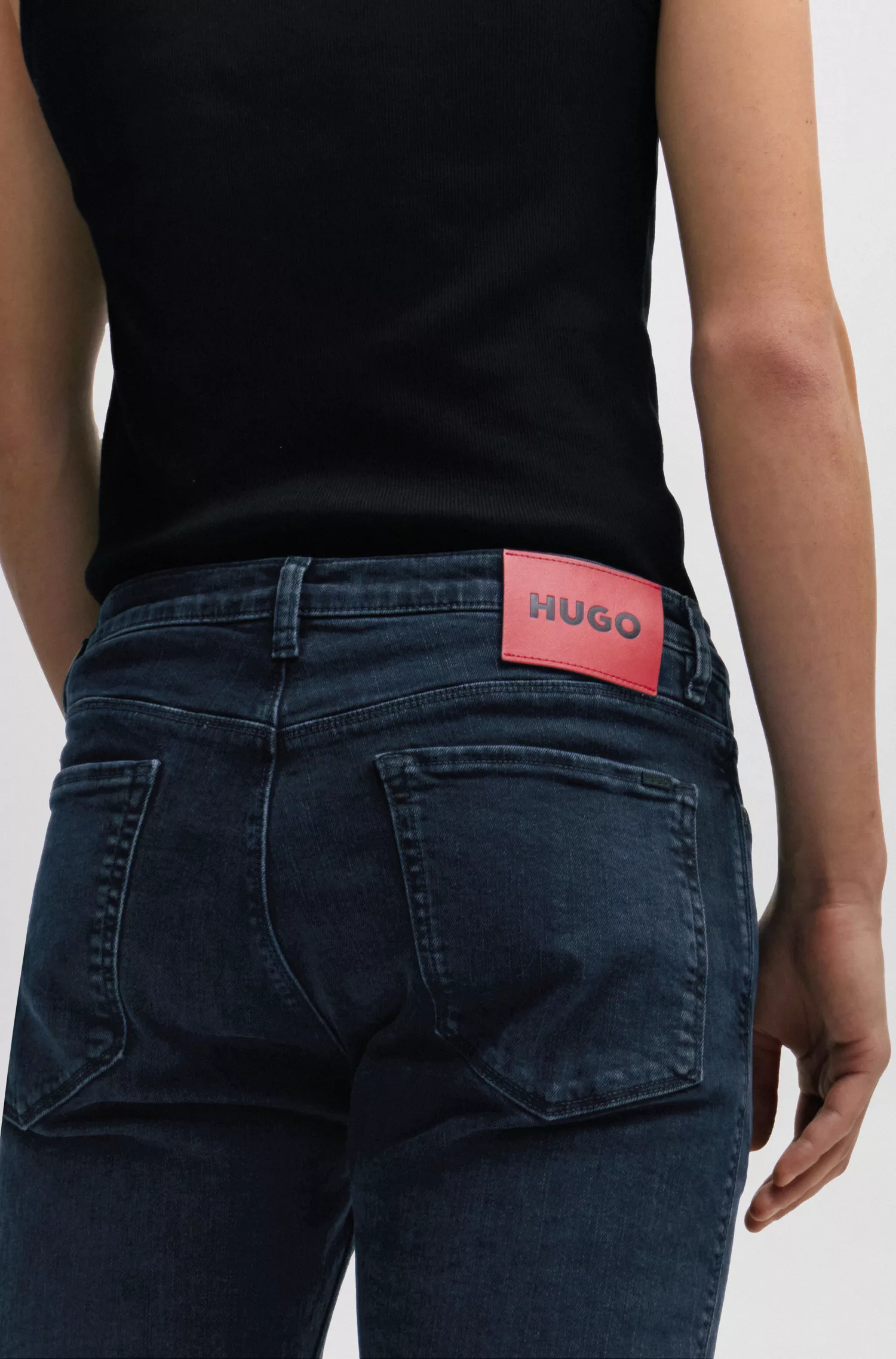 Calça jeans HUGO vermelha, corte slim, em denim stretch azul-preto.