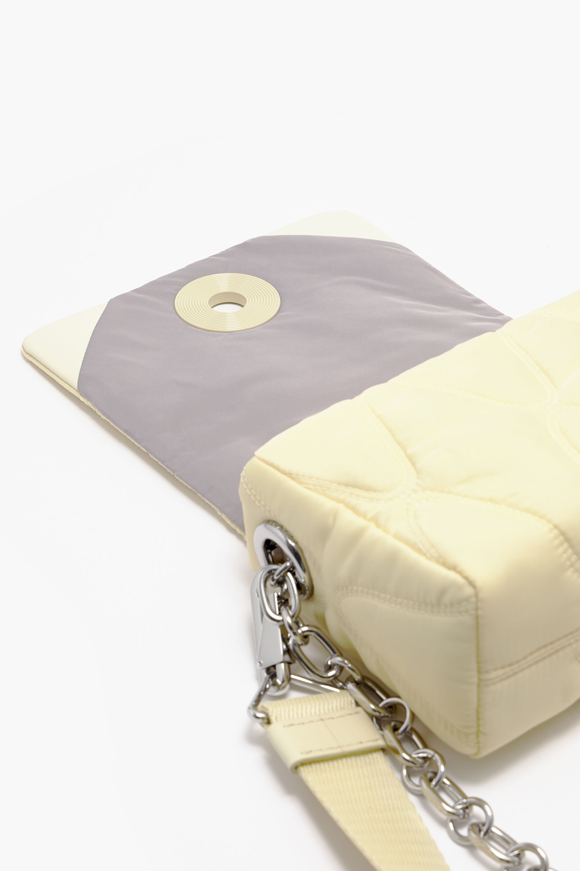 Bolsa transversal pequena de nylon na cor manteiga.