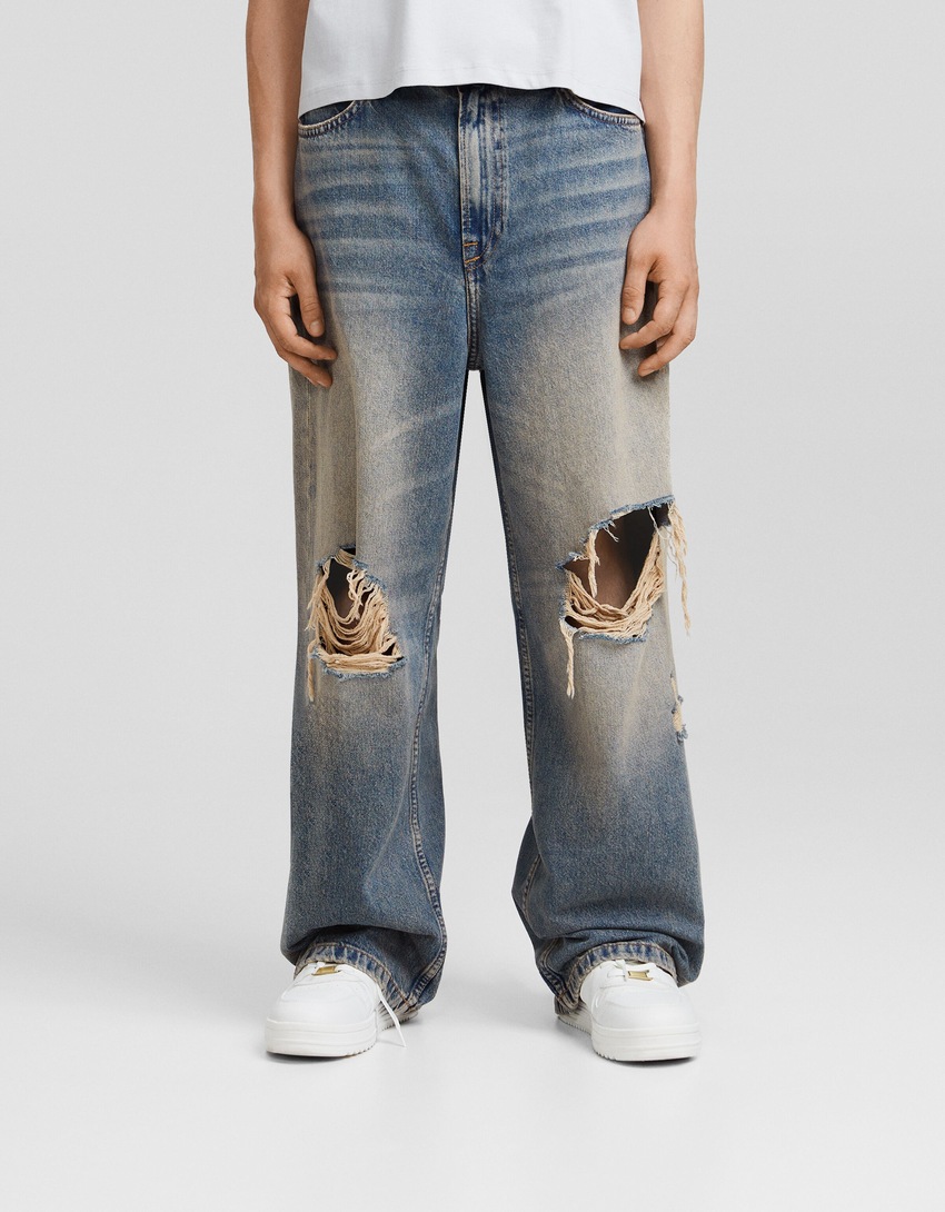 Jeans desbotados, rasgados e super folgados