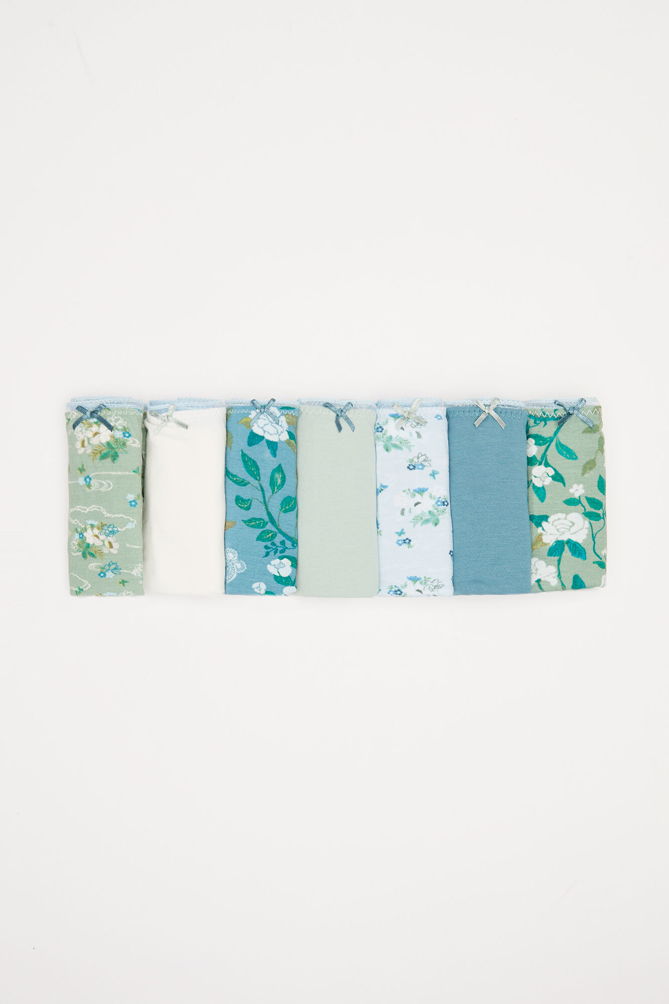 Pacote com 7 calcinhas clássicas de algodão com estampa floral verde.