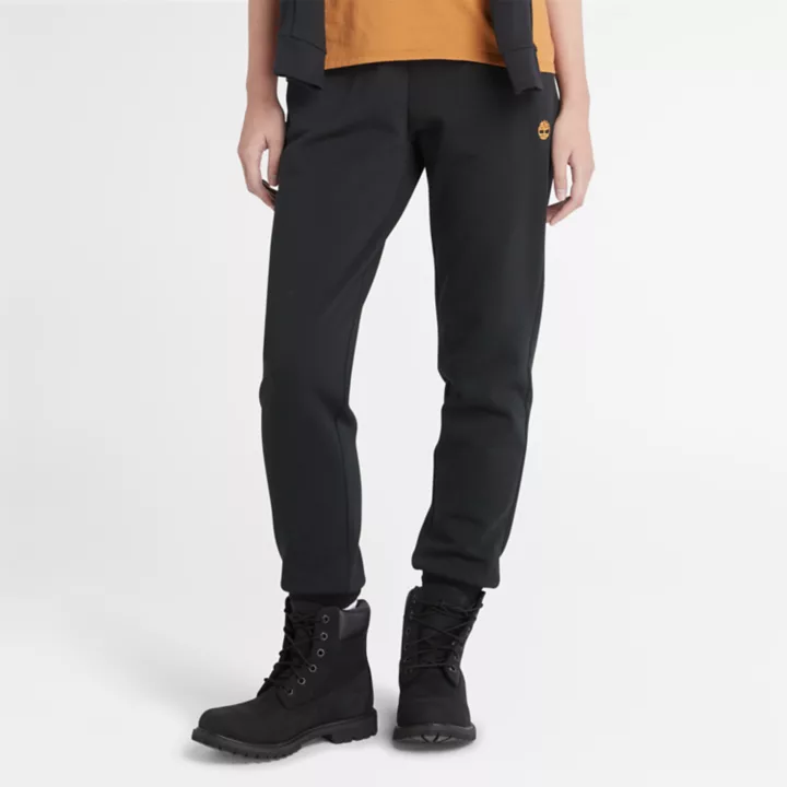 Calça de fato de treino feminina preta com bordado de árvore.