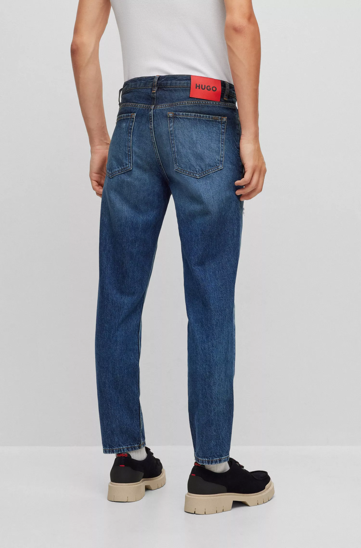 Calça jeans HUGO vermelha, corte afunilado, em denim rígido azul.