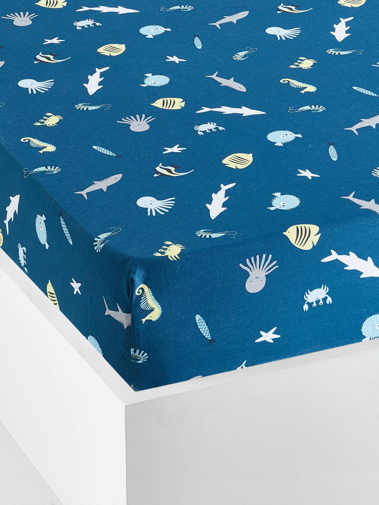 Lençol infantil com elástico, estampa de fundo verde-escuro com motivos marinhos.