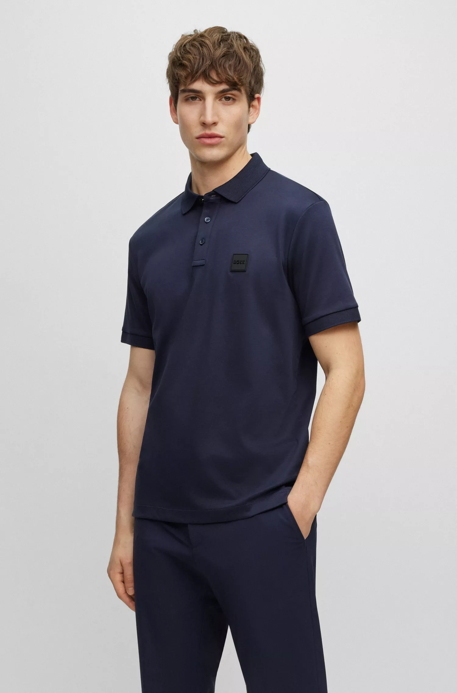 Camisa polo BOSS preta em malha de algodão com emblema da marca.