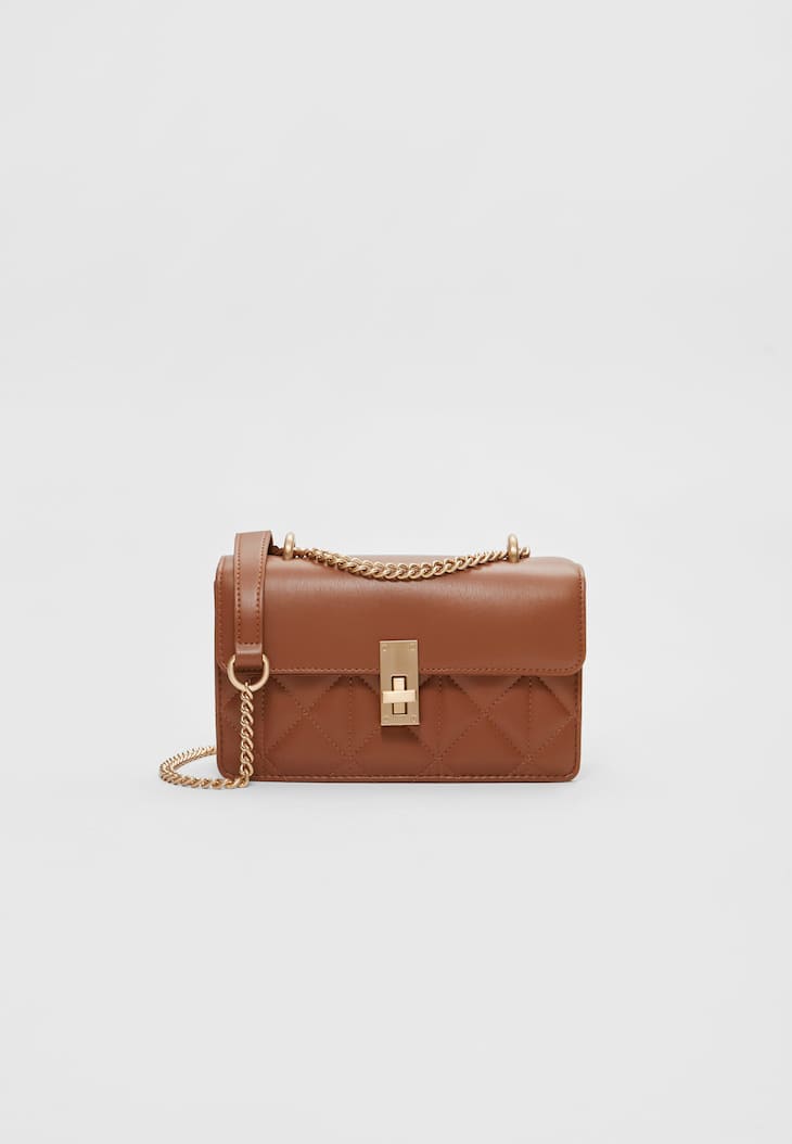 Bolsa transversal com aba e fecho.