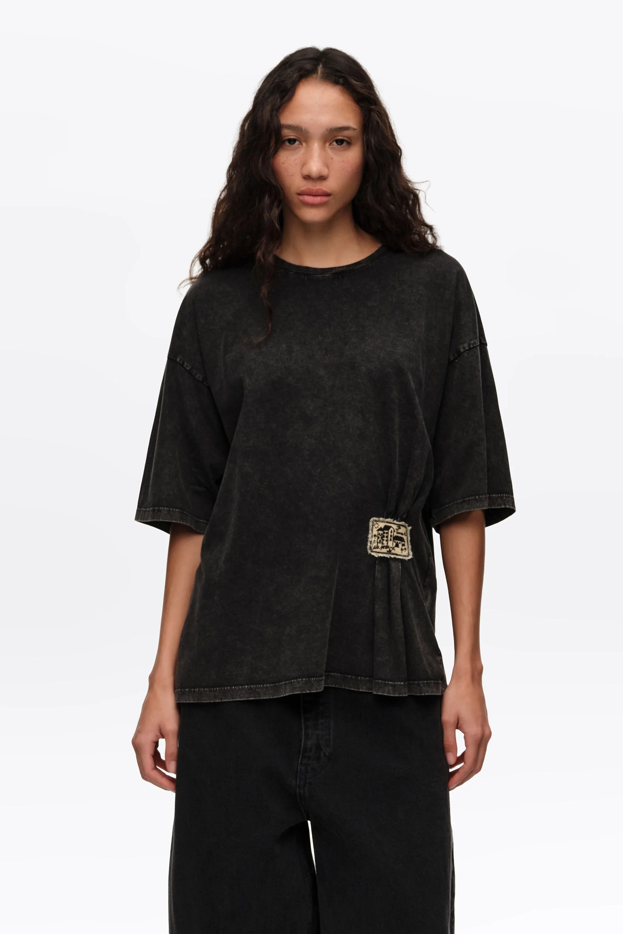 Camiseta preta desbotada com franzidos e etiqueta personalizada.