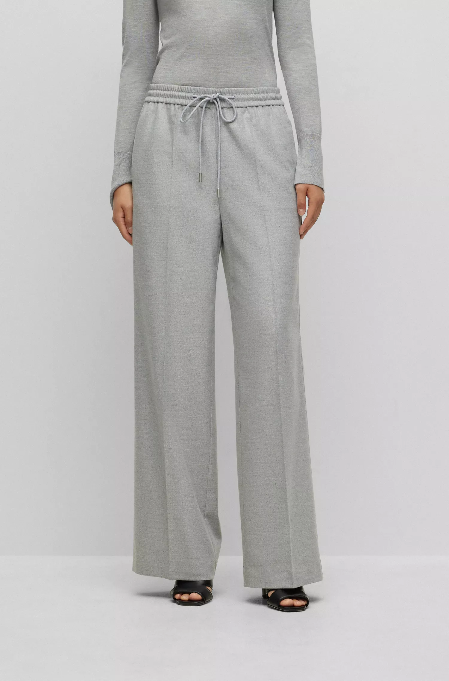 Calça BOSS preta, corte relaxado, com detalhe da marca no cós.