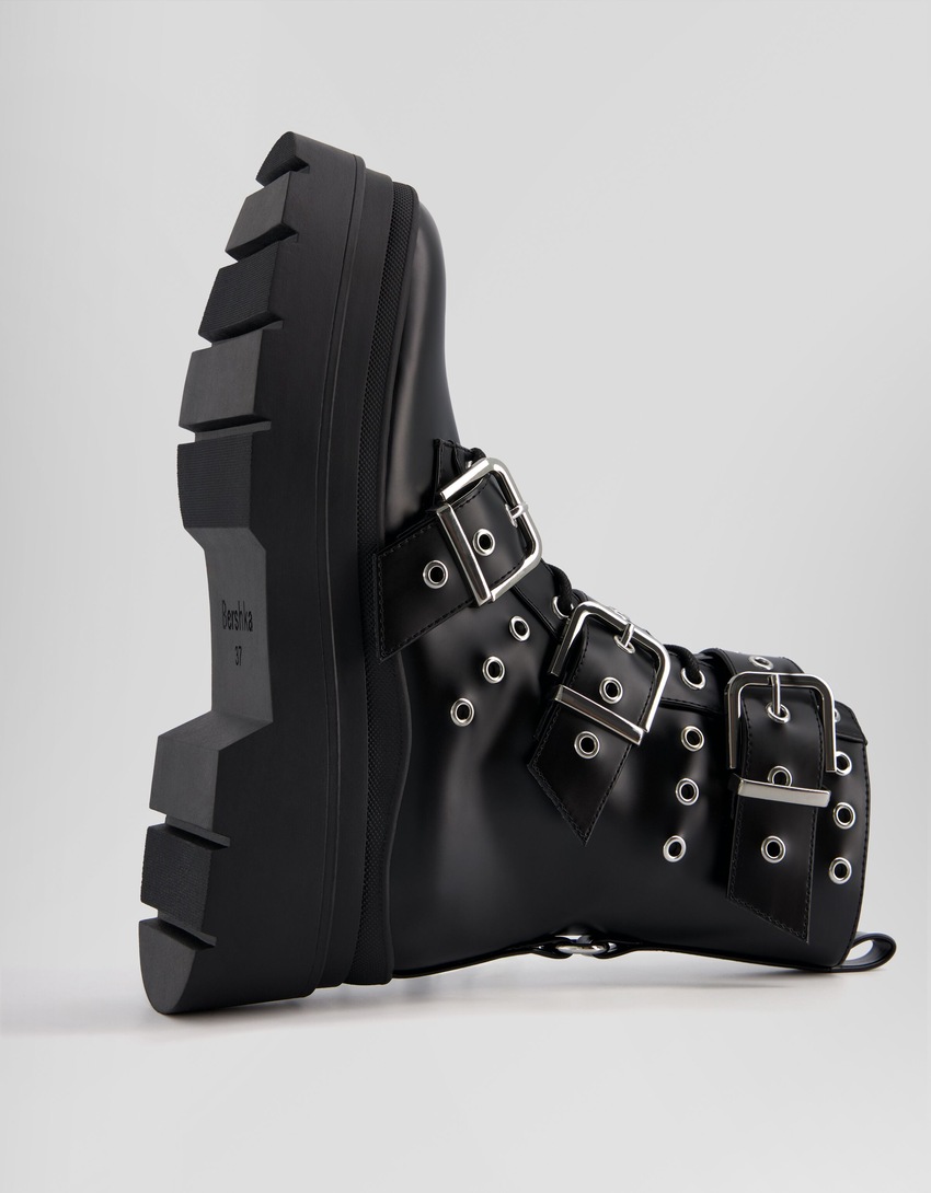Botas de cano curto sem salto, com tiras, ilhós e fivelas.