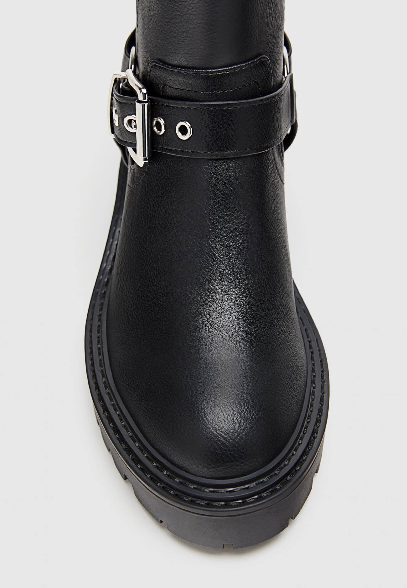 Botas de cano curto estilo motociclista, sem salto, com detalhes de fivela.