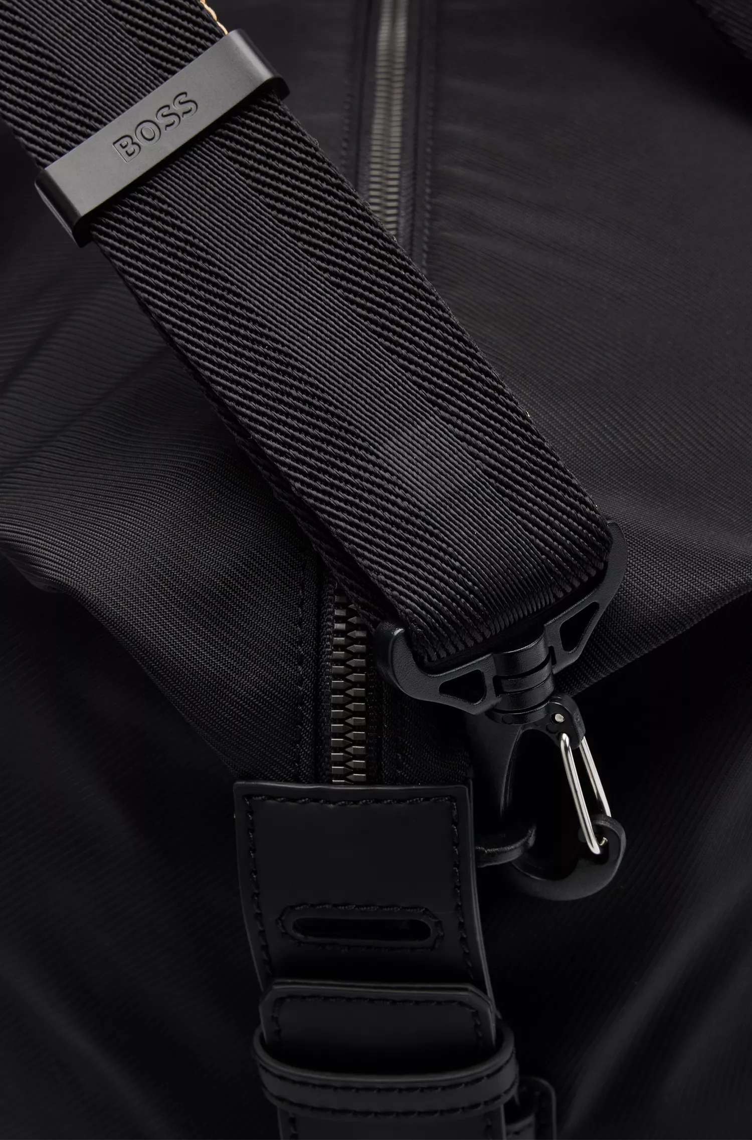 Mala de viagem BOSS com logotipo em contraste preto e alças com listras características.