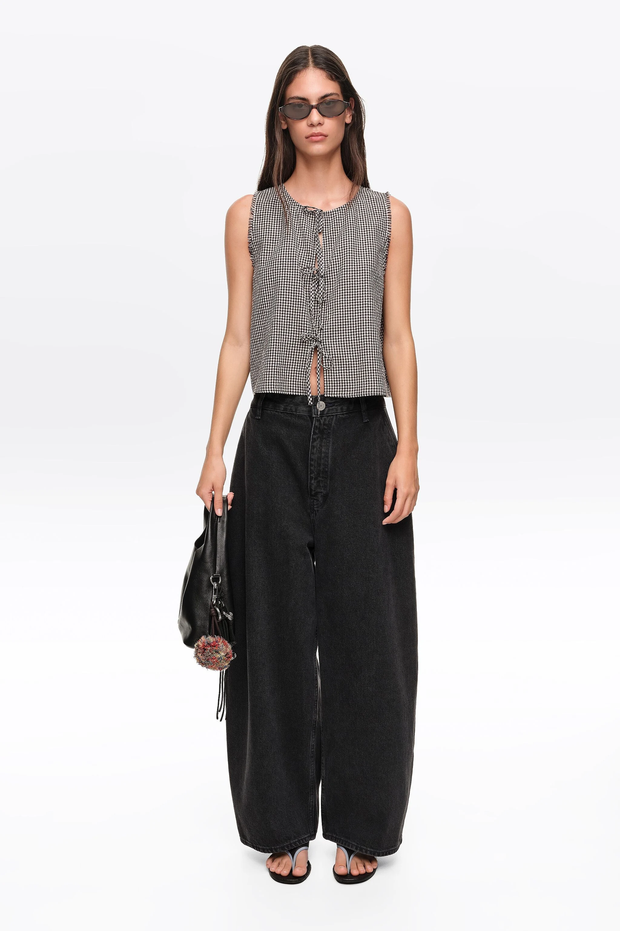 Blusa xadrez preta com laços e detalhes desfiados.
