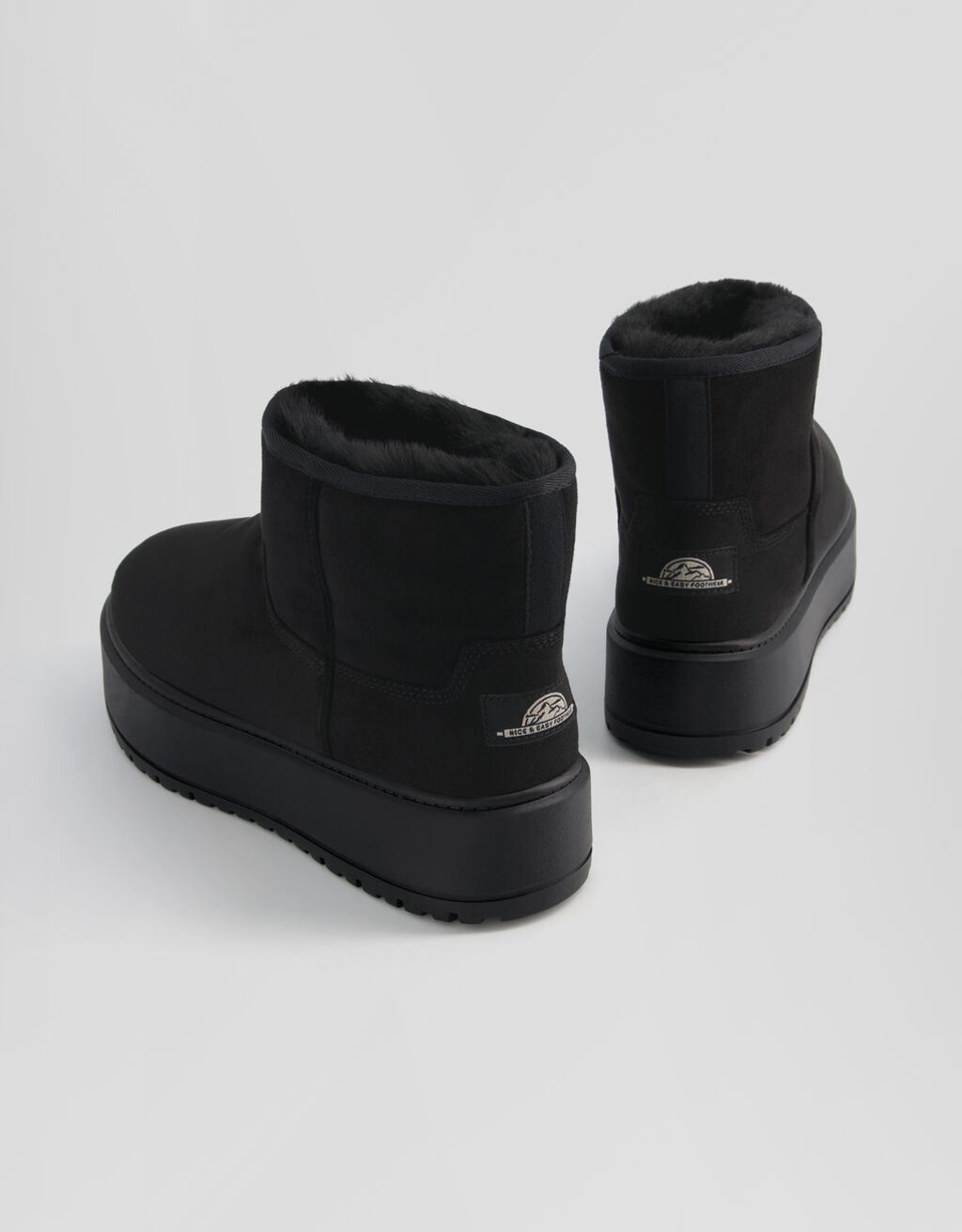 Botas de cano curto com plataforma e forro de pele sintética.
