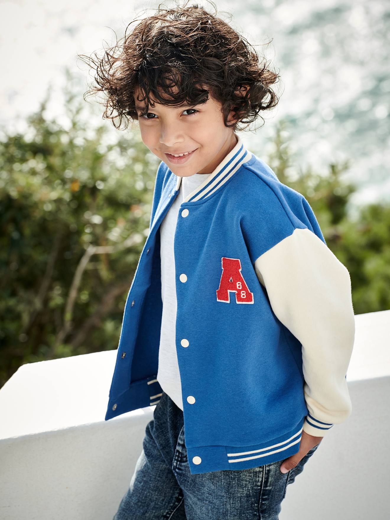 Moletom universitário azul infantil estilo teddy com botões de pressão na frente.