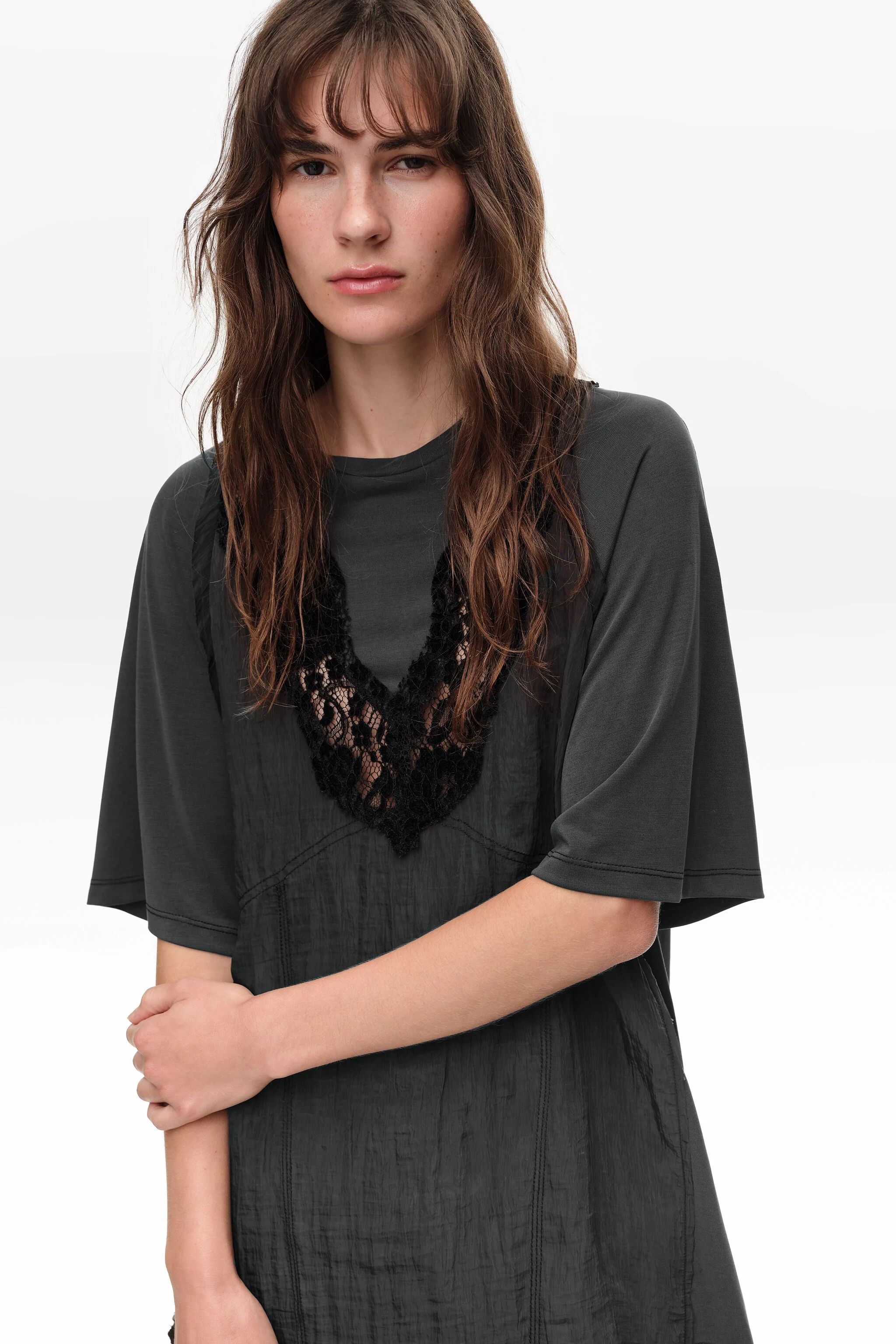 Camiseta preta desbotada com babador e detalhes em renda.