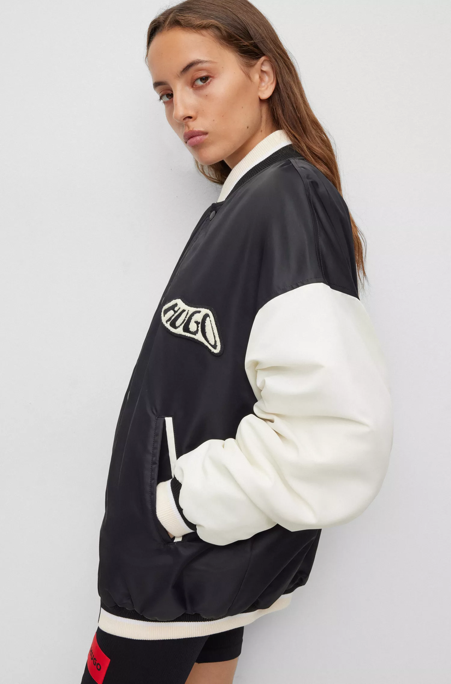Jaqueta bomber estilo universitário HUGO vermelha, repelente à água, com emblema da marca.
