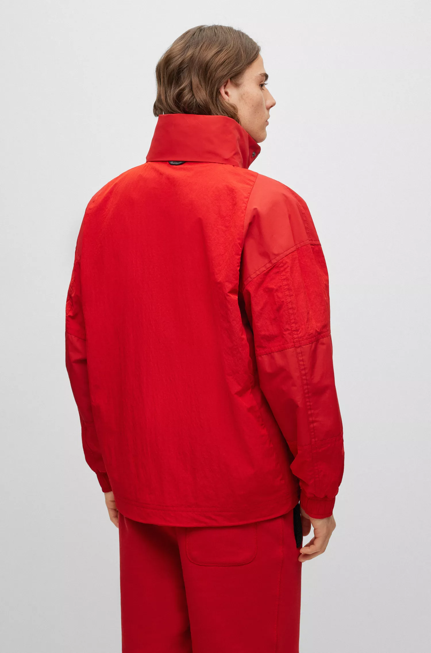 Jaqueta BOSS laranja, modelagem oversized com zíper e detalhes inspirados em corridas.
