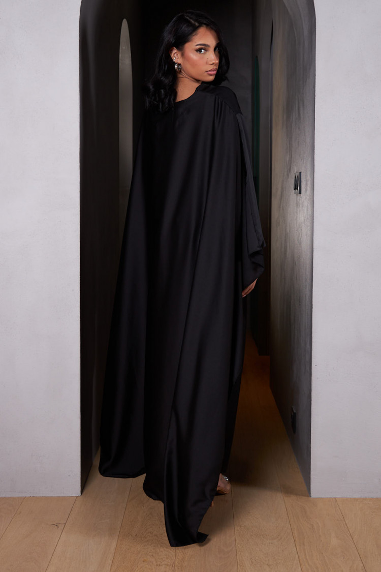 Robe ample ceinturée et satinée noire avec empiècement cape