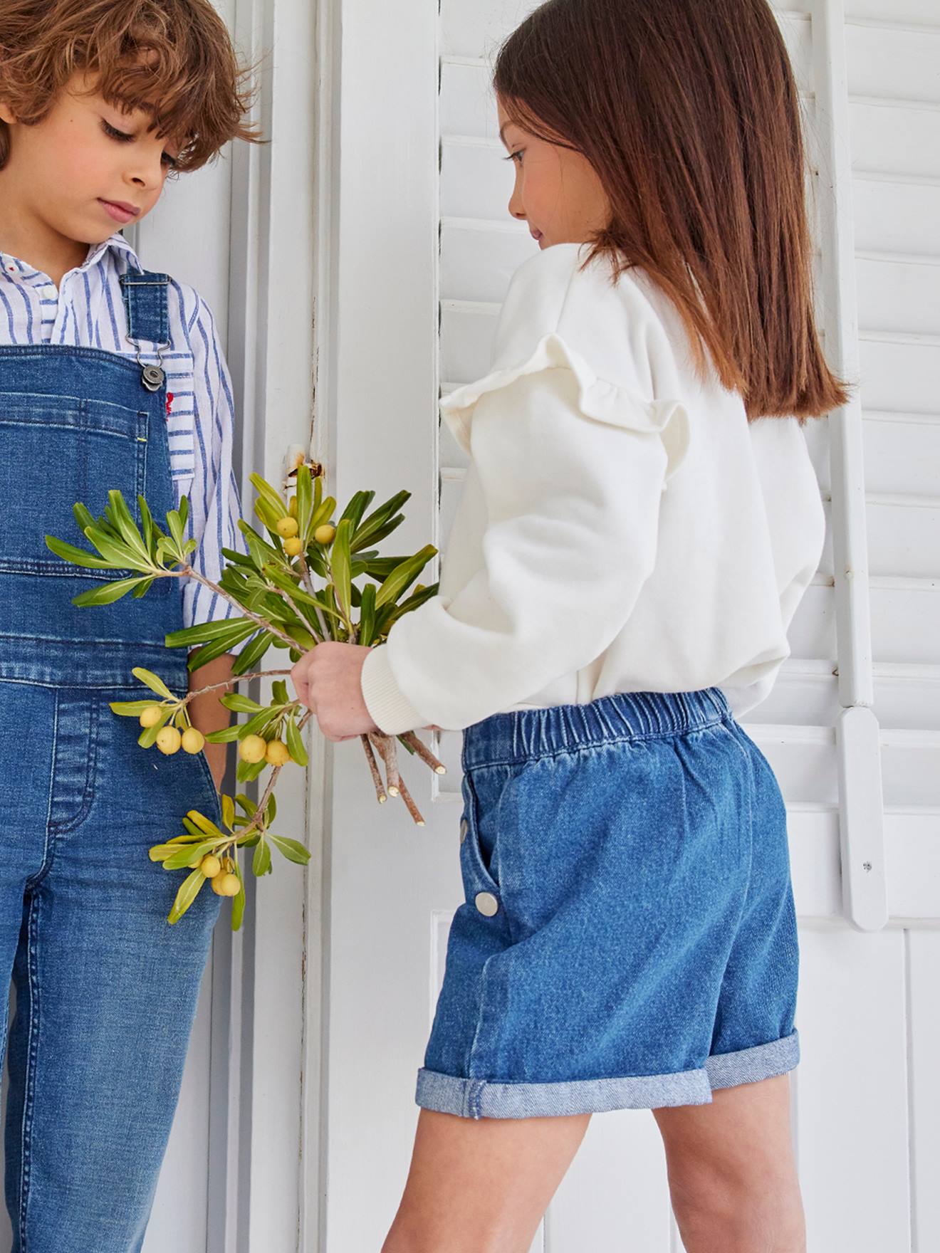 Shorts jeans azul-escuro para meninas com botões decorativos.
