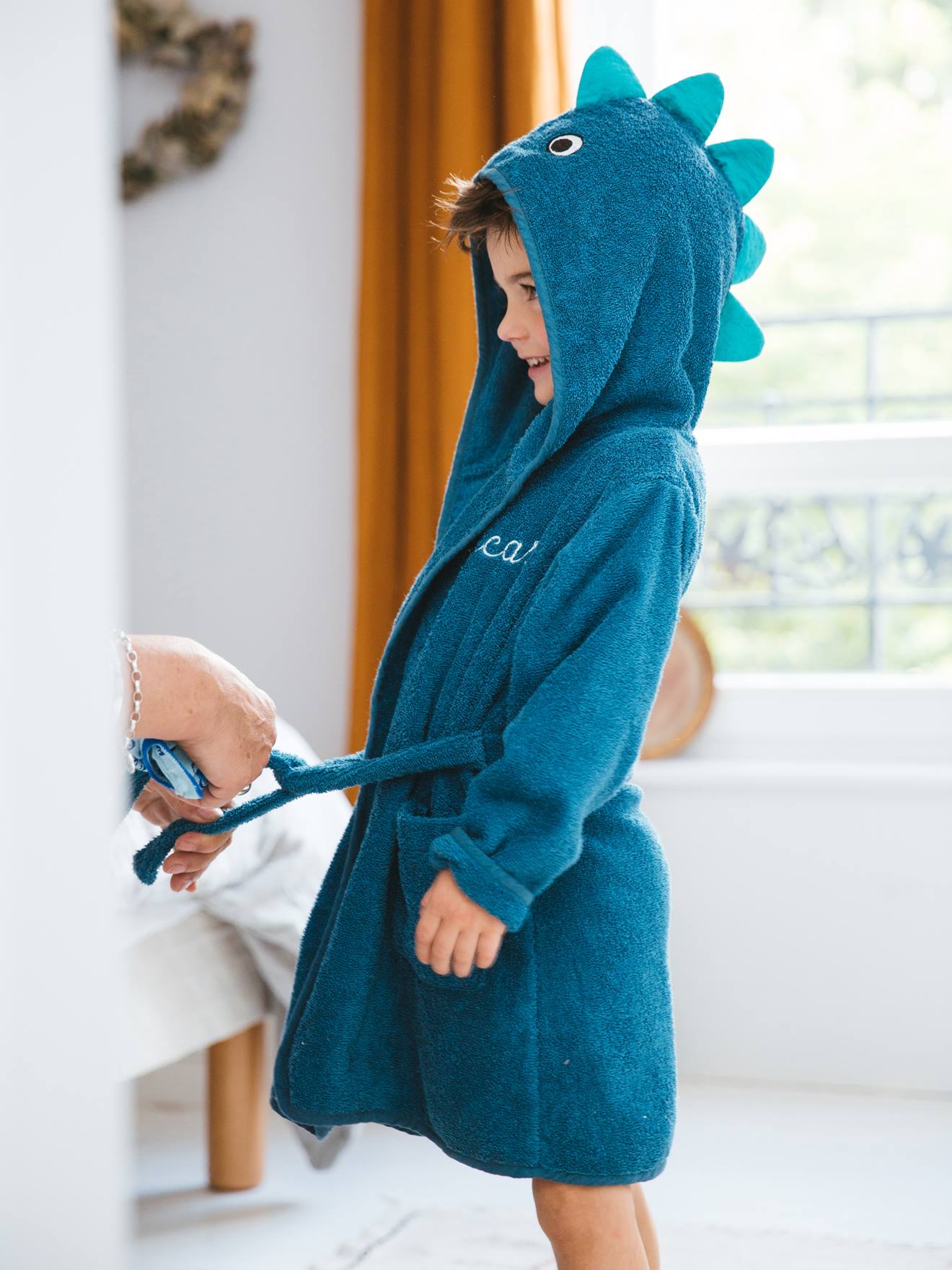 Robe de banho infantil com estampa de dinossauro personalizável, azul liso tamanho médio com detalhes.