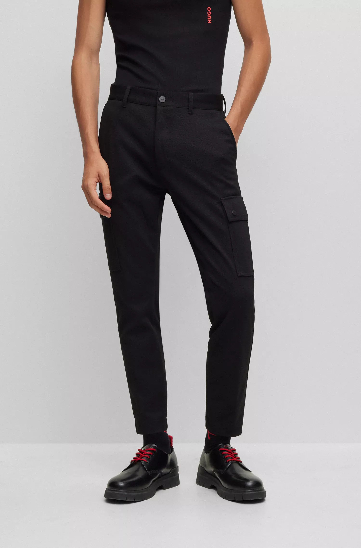 Calça cargo HUGO vermelha, corte slim, em malha estruturada de alta performance com elasticidade.