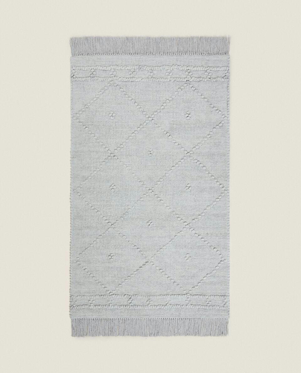 Tapete infantil de chenille com estampa de diamante e franjas.