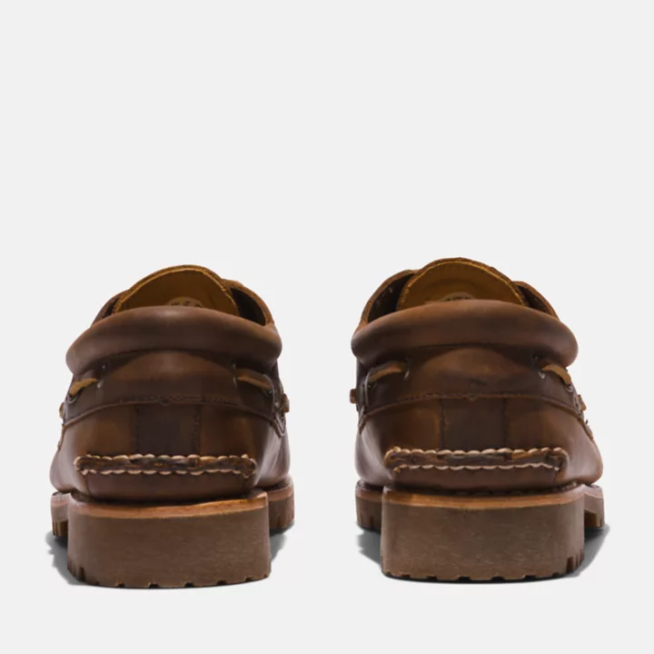 Sapato náutico masculino de três ilhós, costurado à mão, na cor marrom escuro.