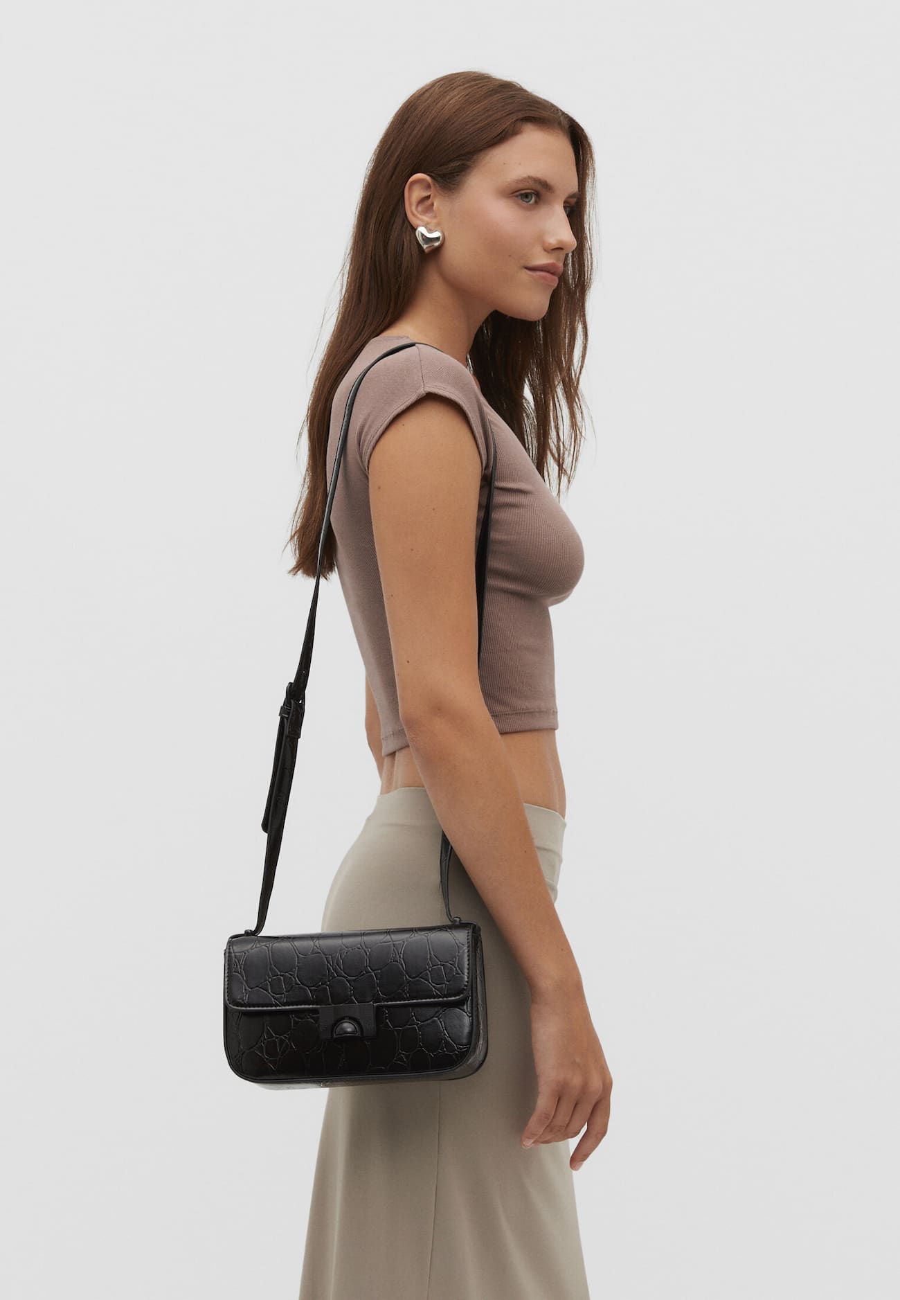 Bolsa transversal com estampa de crocodilo e fecho.
